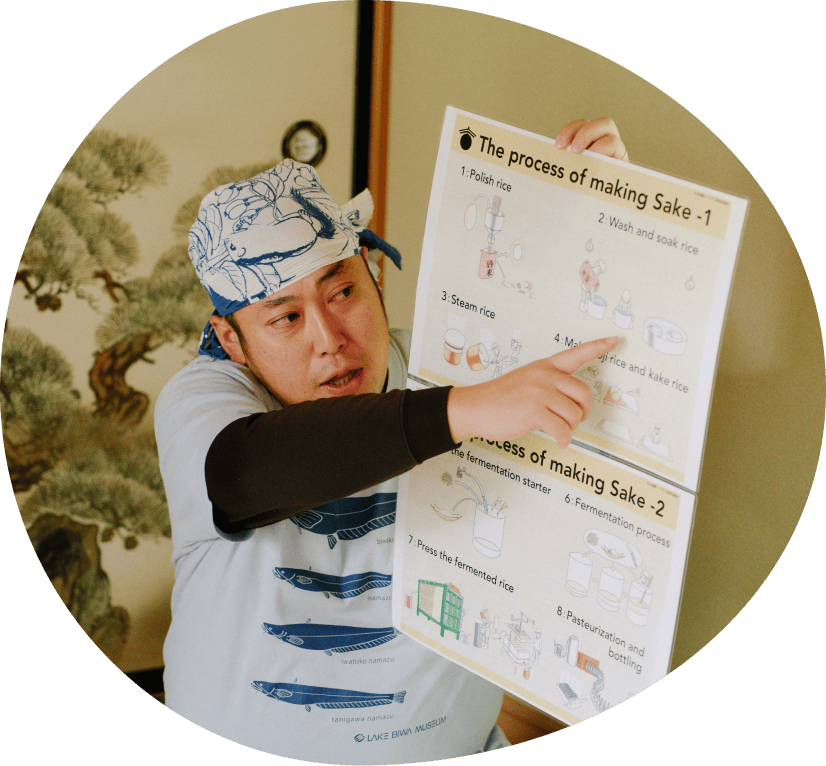 魚の絵が描かれたポスターを持つ青いシャツの男性