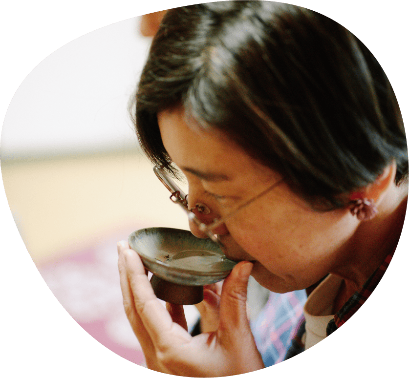 女性がカップからお酒を飲んでいる様子